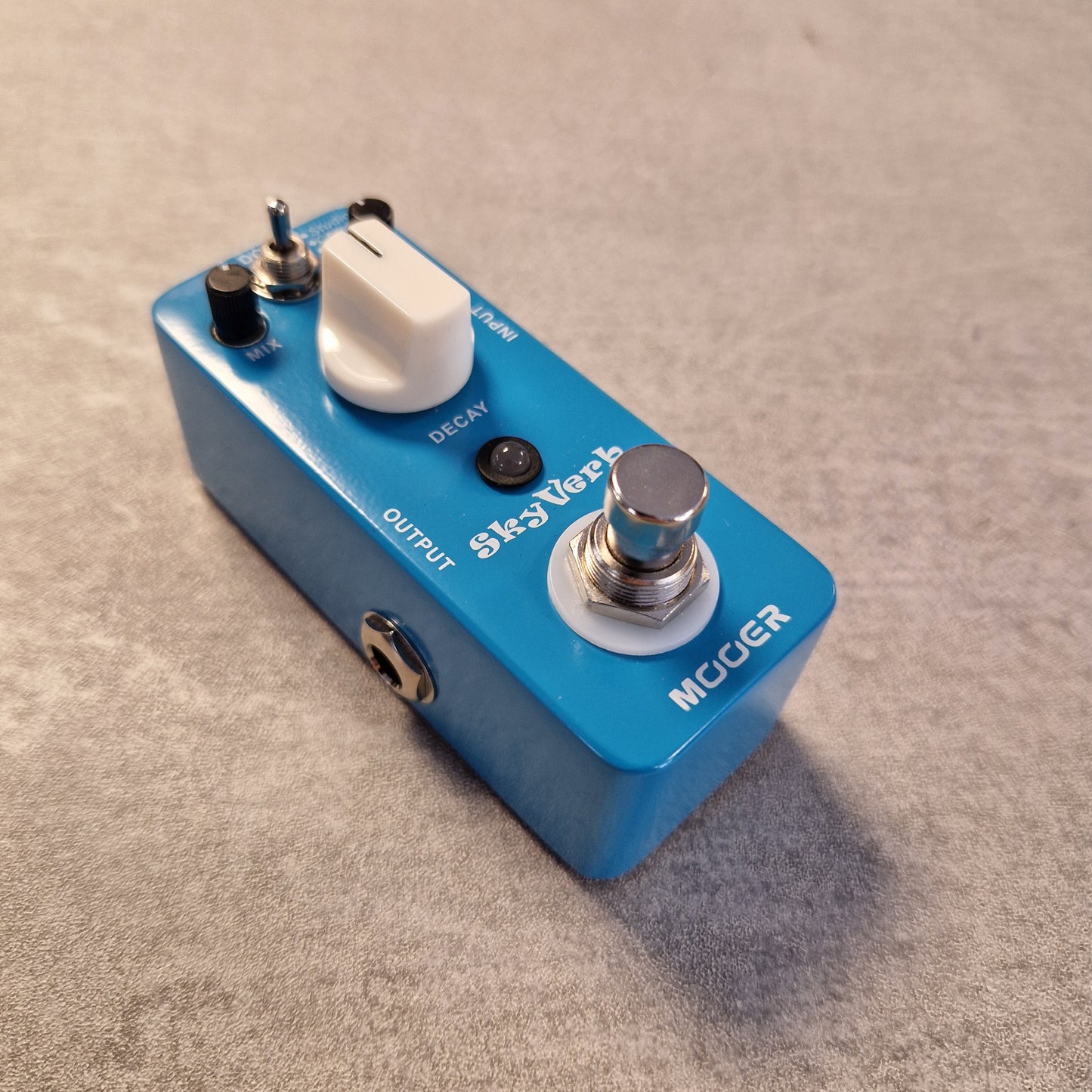 Pre-Owned Mooer MRV2 Blue guitar effects pedal with 'Mogee' branding on a beige surface