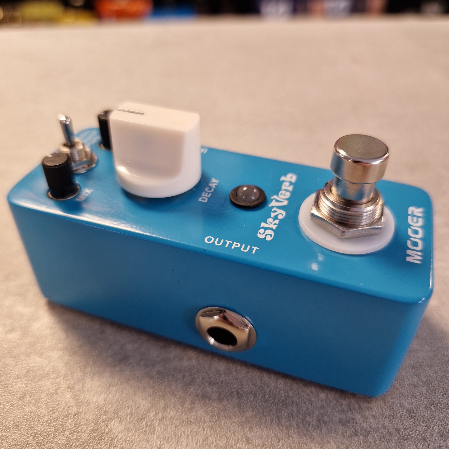 Pre-Owned Mooer MRV2 Blue guitar effects pedal with visible branding on a textured surface