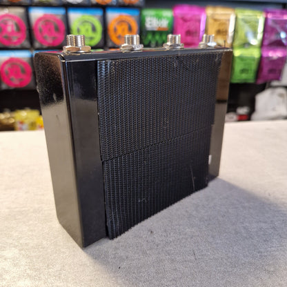 Pre-Owned Truetone VSXO Black speaker grill on a stand with colorful objects in the background