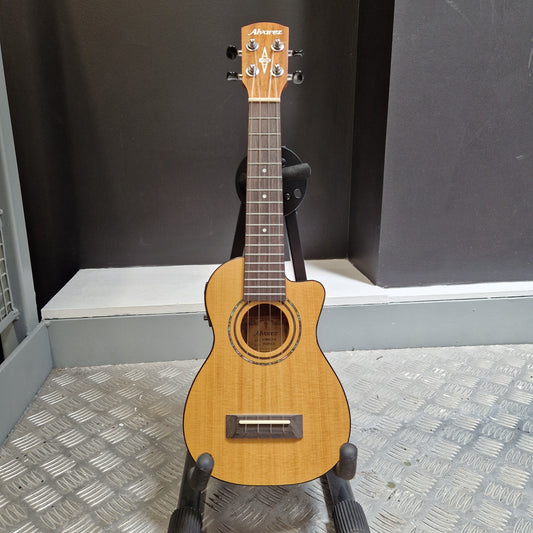 Pre-Owned Alvarez RU26CCE Small acoustic guitar held against a textured wall and black background