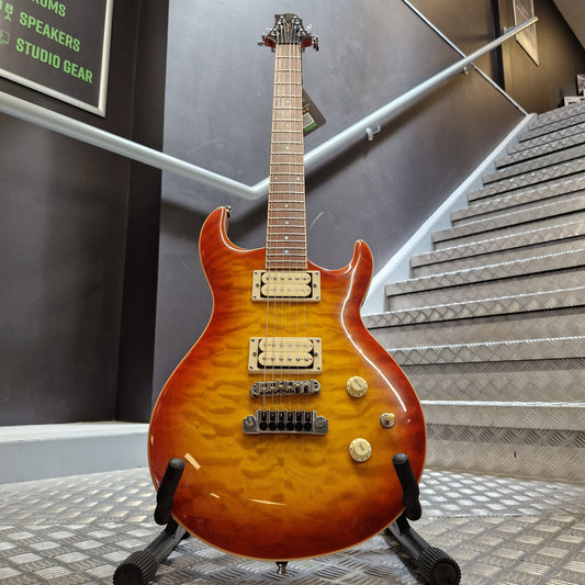 Pre-Owned Samick Orange electric guitar on a stand with a room interior in the background
