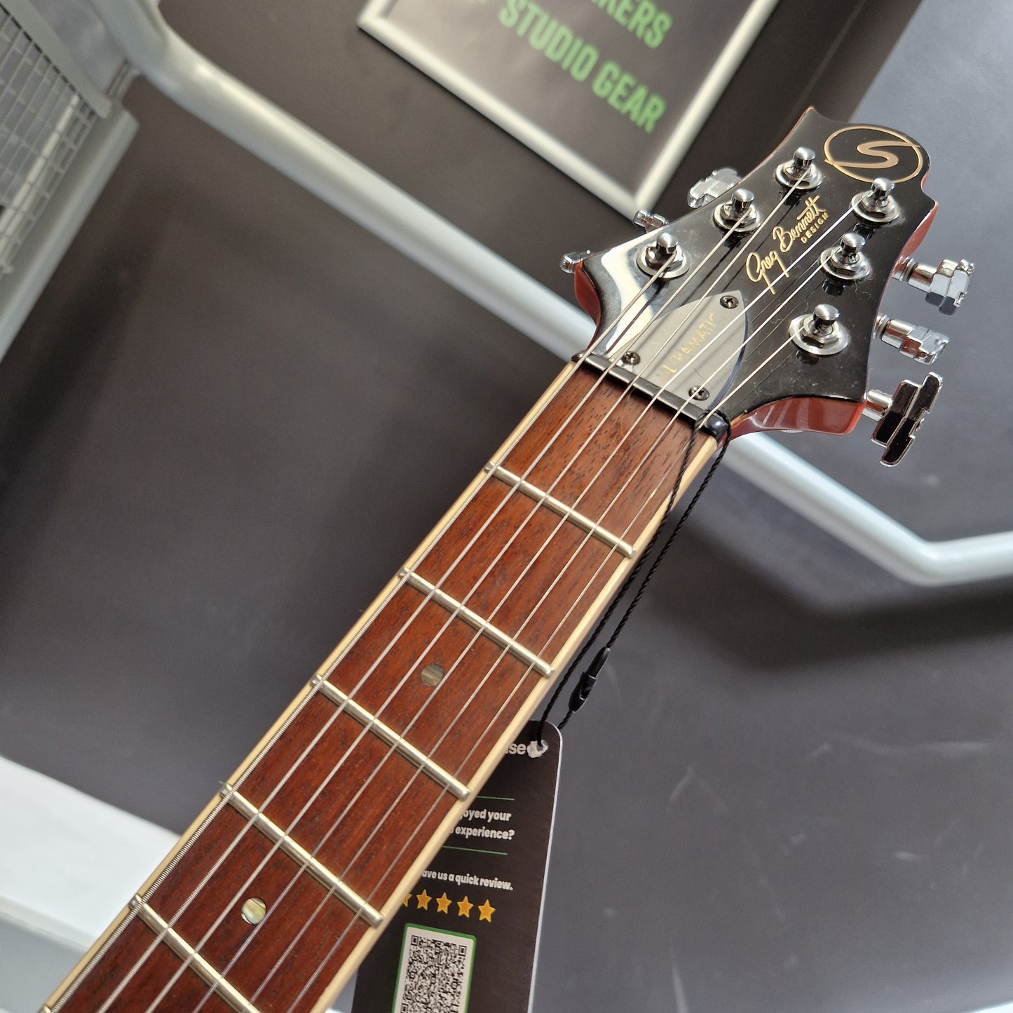 Pre-Owned Samick Close-up of a guitar neck with headstock, blurred background