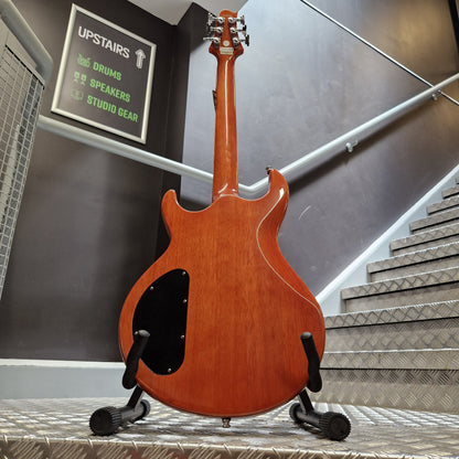Pre-Owned Samick Electric guitar hanging on a wall with a sign and equipment below