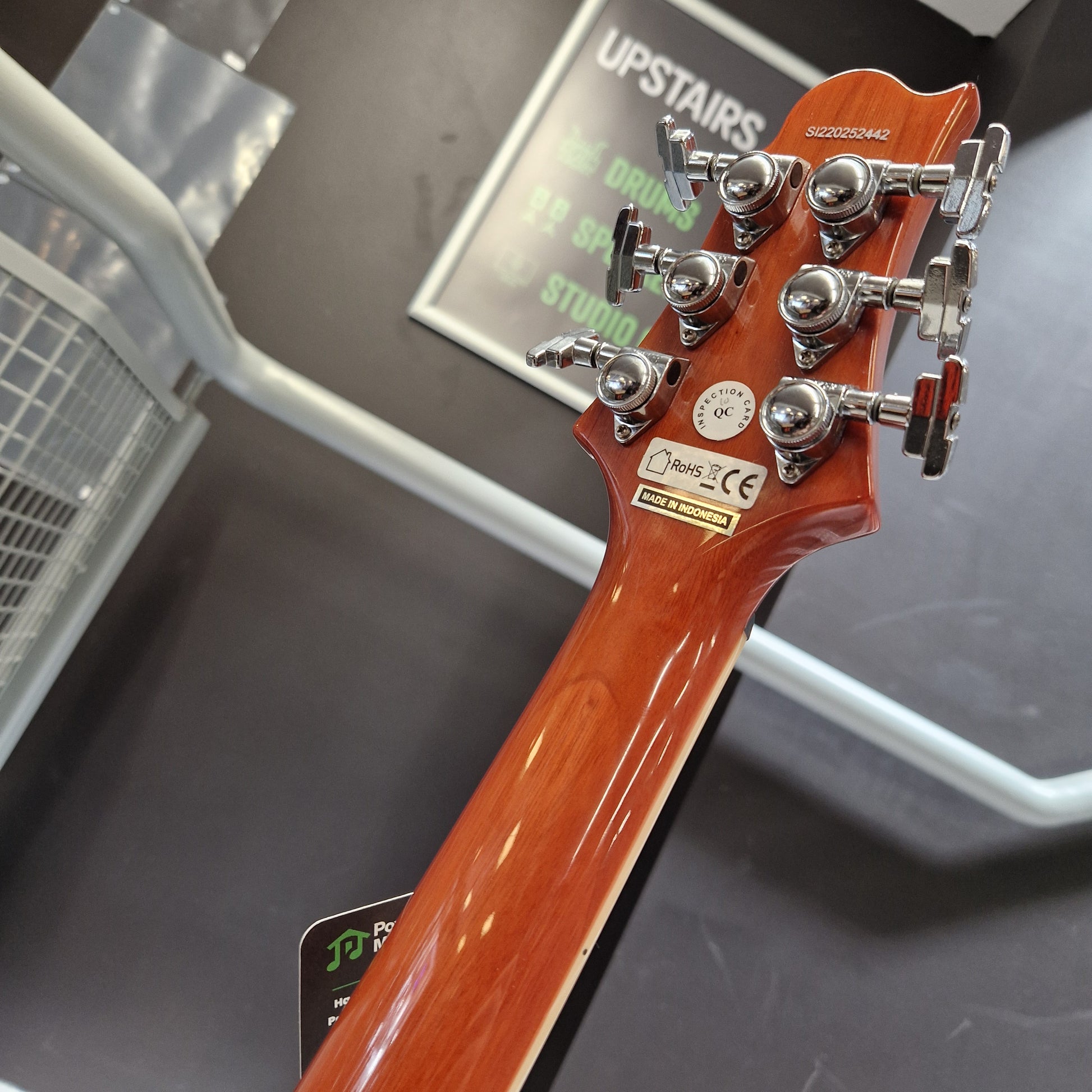 Pre-Owned Samick Close-up of a guitar neck with tuning pegs on a blurred background