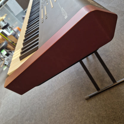 Pre-Owned Yamaha MOXF8 Close-up of a computer case with a brown top cover on a blurred background