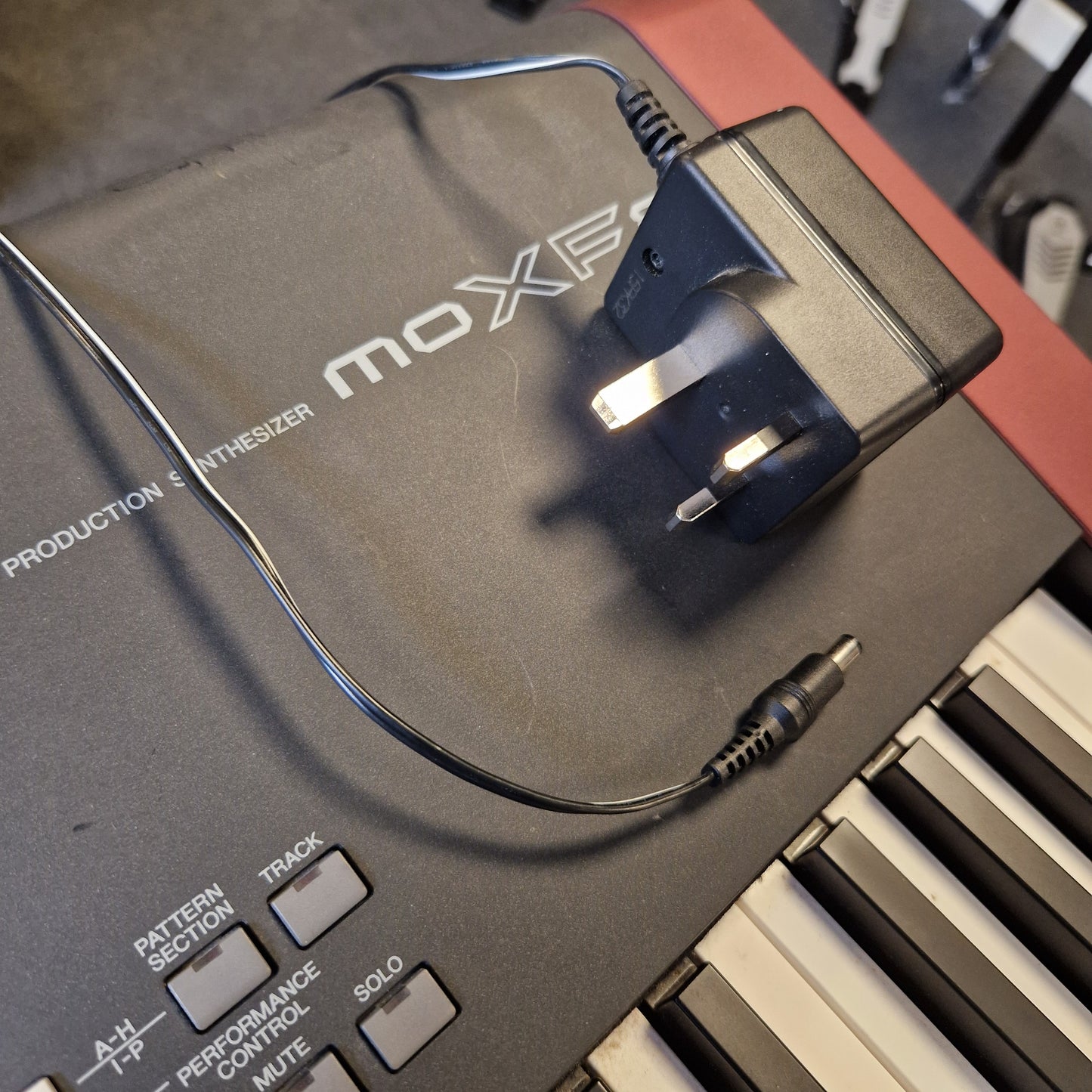 Pre-Owned Yamaha MOXF8 MOXIE power adapter and cable on a keyboard