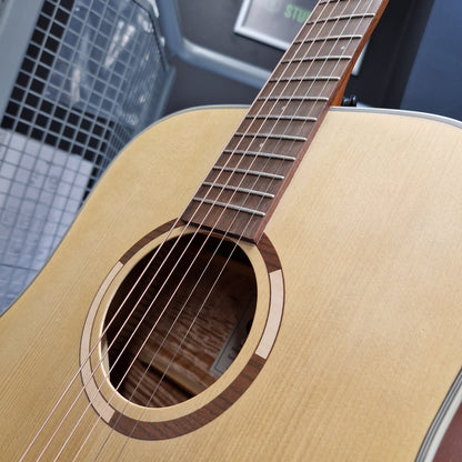 Pre-Owned Tanglewood TS5 Close-up of a wooden acoustic guitar with a blurred background