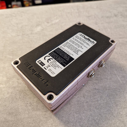 Pre-Owned Digitech Grunge Logitech electronic component with a black faceplate, silver screws, and a white product label, photographed on a gray textured surface.