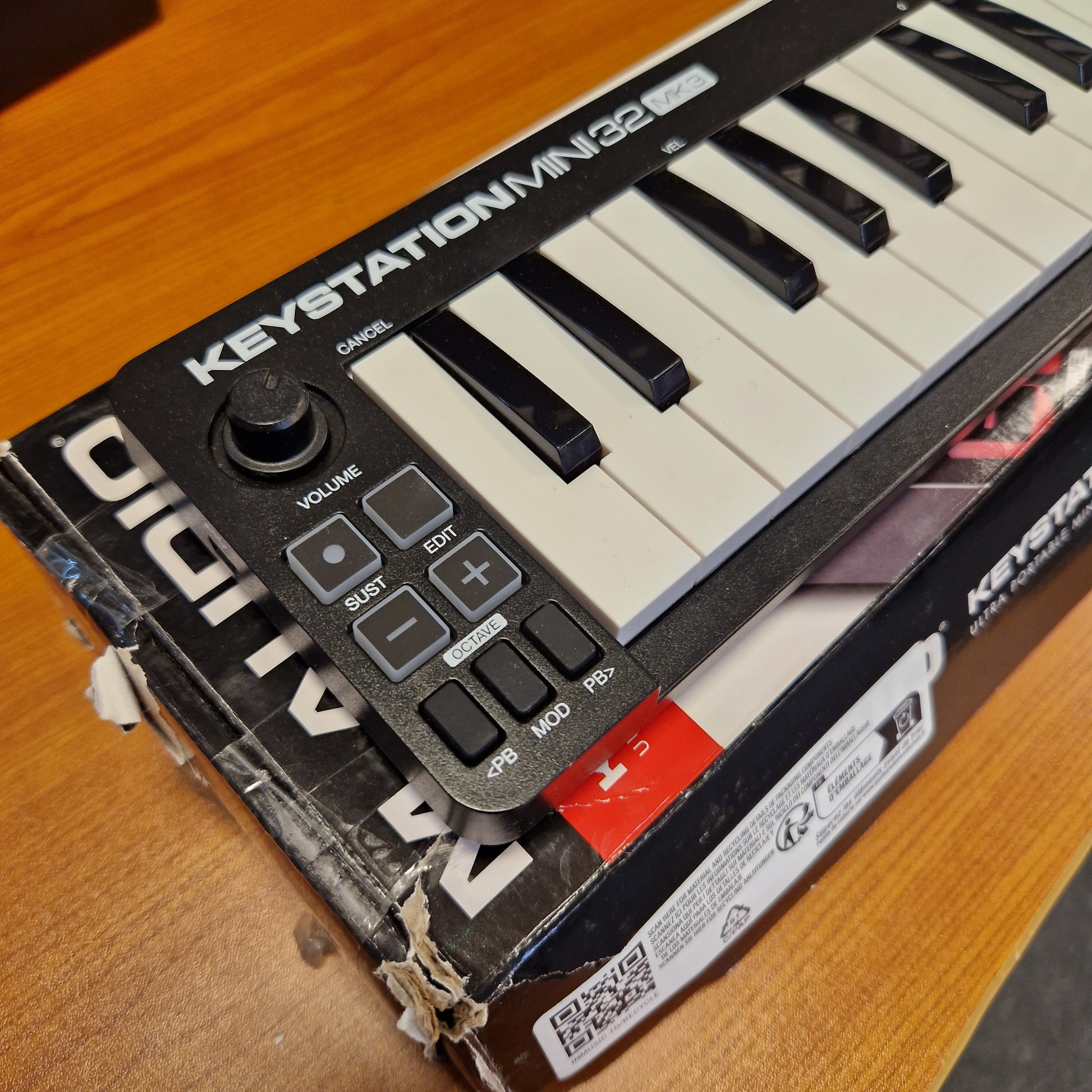 Pre-Owned M-Audio Keystation A close-up of a Korg Mini Studio 133 electronic keyboard resting on top of its original retail box, placed on a wooden surface.