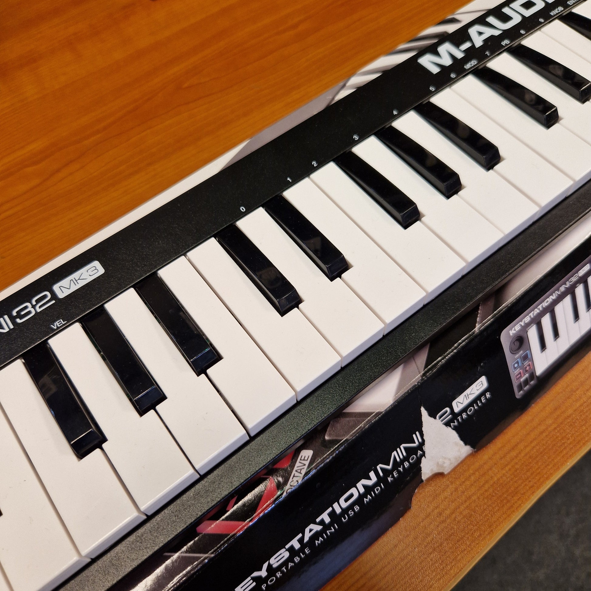 Pre-Owned M-Audio Keystation A close-up diagonal view of a Maudio Synstation 22 synthesizer keyboard, showing black and white keys, the brand name 'MAUDIO' on the black panel, and the Synstation 22 logo on the side.