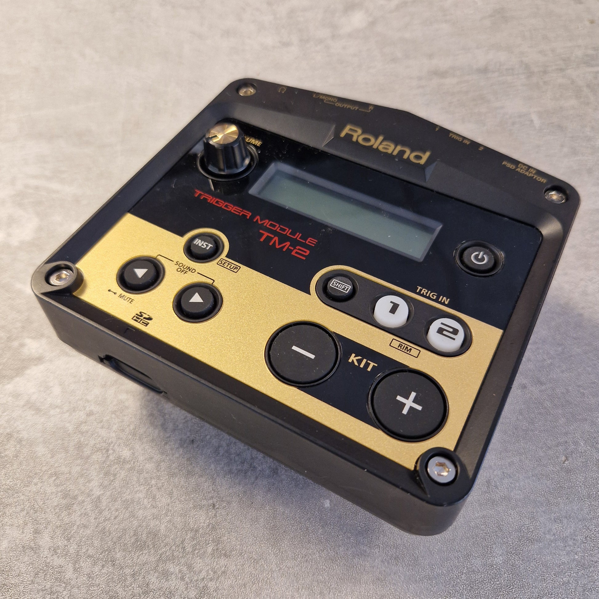 Pre-Owned Roland TM-2  Roland TD-1020 Modulars TME2 digital audio module in black and gold, photographed on a textured gray surface.