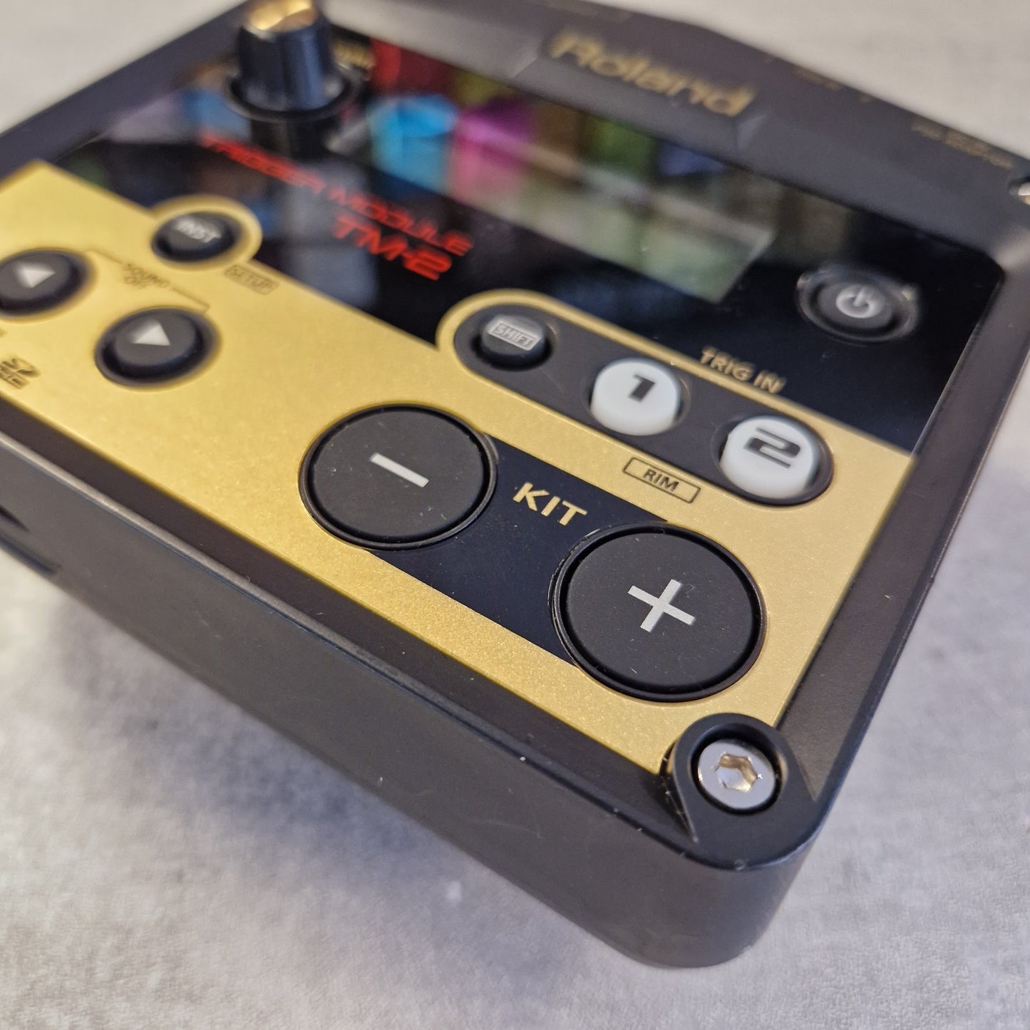 Pre-Owned Roland TM-2 Close-up of a Roland TW2 electronic music controller showing the control panel with gold and black buttons on a gray surface.