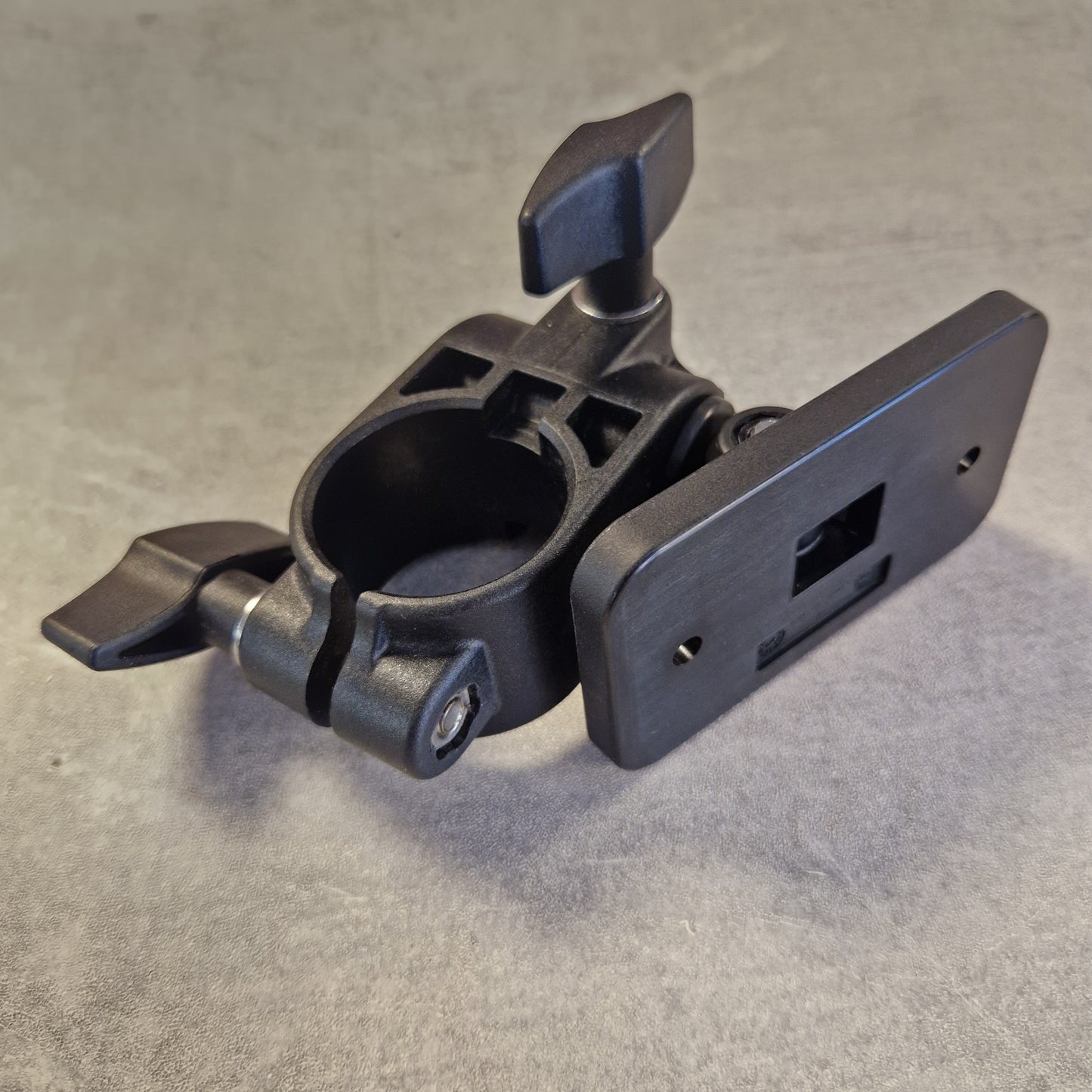 Pre-Owned Roland TM-2 A dark gray metal mounting clamp with a rectangular plate on top and two adjustable wing nuts, photographed against a textured gray background.