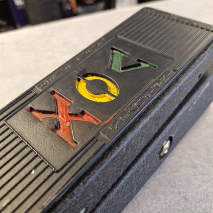 Pre-Owned Vox V845 Close-up of a black textured electronic device with the letters 'VOX' in green, yellow, and red on the front.