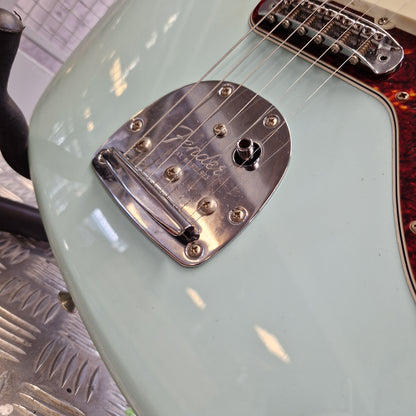 Pre-Owned Fender Close-up of a Fender electric guitar body in a pale mint green finish, showing the chrome tremolo bridge and part of the neck joint.
