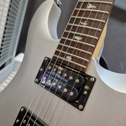 Pre-Owned PRS SE CE24 Close-up of an electric guitar body and neck, showing a matte light gray or silver finish, dark wood fretboard, metal strings, and black hardware.