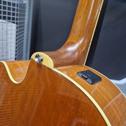 Pre-Owned Yamaha CPX700 Close-up detail of a wooden acoustic guitar body showing the glossy wood grain, cream binding, and a black pickup component.