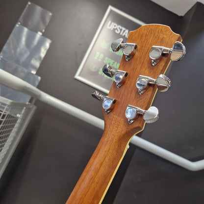 Pre-Owned Yamaha CPX700 Close-up of the headstock of a wooden stringed instrument, showing six silver tuning pegs on a warm brown wood neck, photographed indoors against a dark gray background.