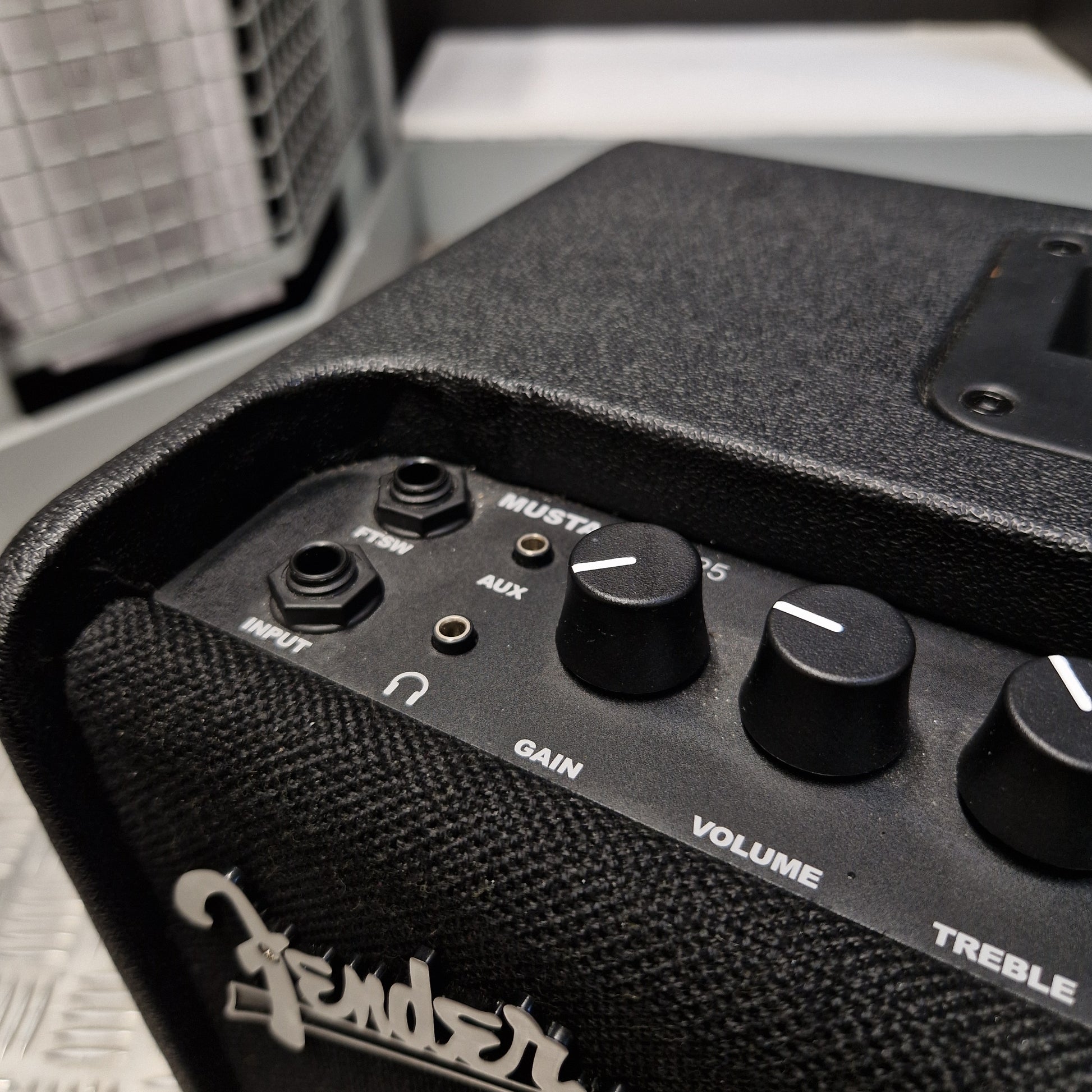 Pre-Owned Fender Close-up of a black Fender guitar amplifier control panel with knobs labeled Master, Bass, Volume, Gain, Treble, and Output, showing the Fender logo on the side.