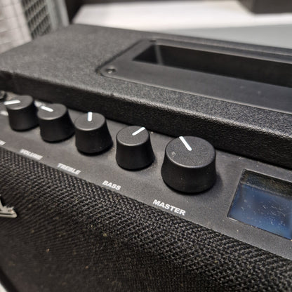 Pre-Owned Fender Close-up of a black electronic speaker or amplifier control panel with multiple rotary knobs and a small display screen.