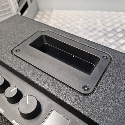Pre-Owned Fender Close-up of a black textured speaker cabinet showing a rectangular speaker grille cutout and part of the control knobs.