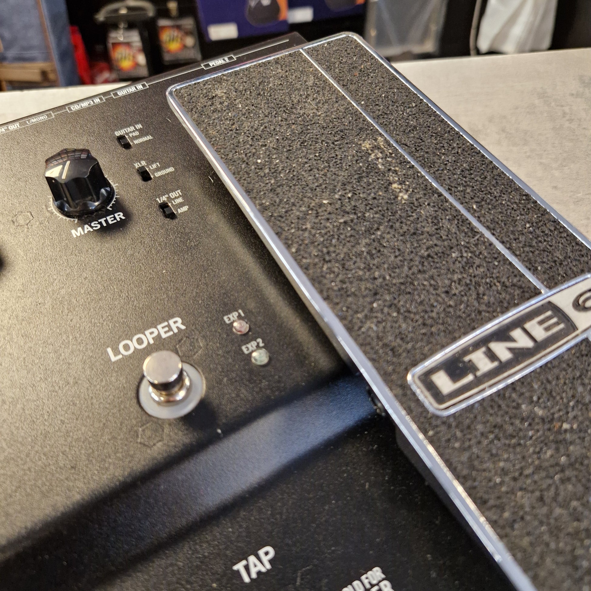 Pre-Owned Line 6 Close-up of a Line 6 Looper pedal guitar effect module, showing the textured black footplate, white brand logo, master knob, tap switch, and loop jack connector.