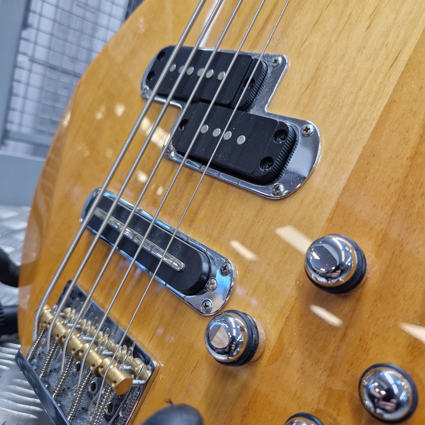 Pre-Owned Yamaha BB615 Close-up of a natural wood electric bass guitar body showing the pickups, bridge, and control knobs.