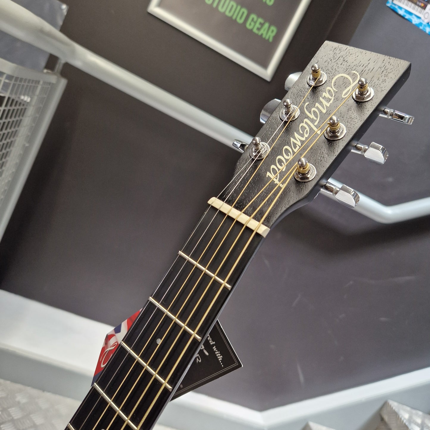 Pre-Owned Tanglewood TWBBSFCELH Close-up of a Canelewood acoustic guitar headstock and neck, showing the brand name in gold script on a dark wood headstock with silver tuning pegs.