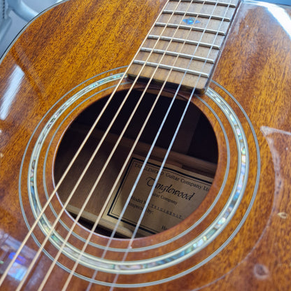Pre-Owned Tanglewood TW15ASMNAT Close-up of a Taylorwood acoustic guitar's sound hole and neck, showing the wood grain, strings, and brand label inside the sound cavity.