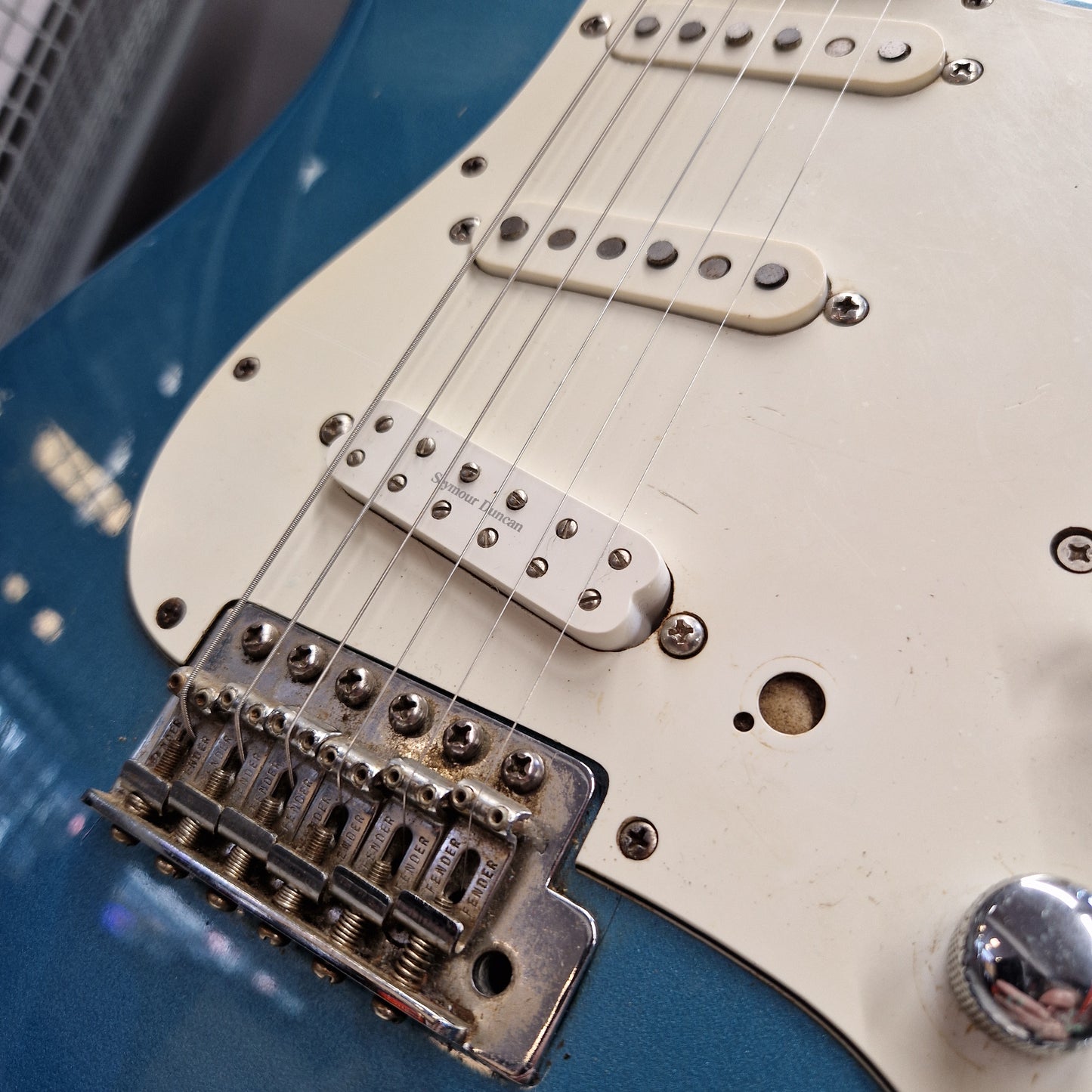 Pre-Owned Fender Mexican Stratocaster 1993 Electric - Lake Placid Blue Close-up of a blue electric guitar body with a cream pickguard, dual humbucker pickups, and a chrome bridge.