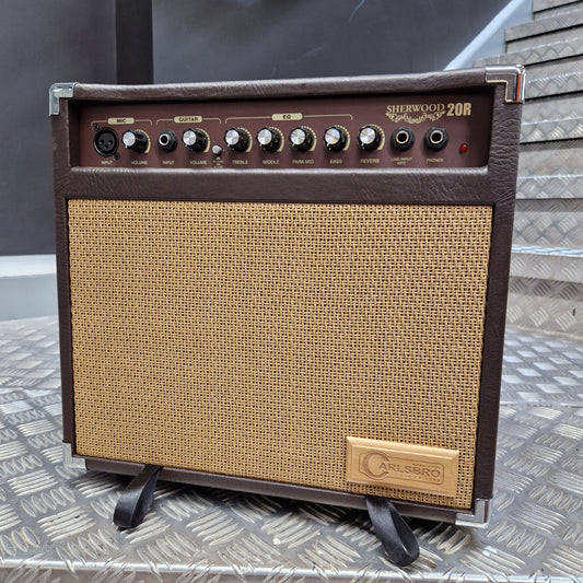 Pre-Owned Carlsbro Sherwood 20R A small guitar amplifier with a dark brown faux-leather front, a tan woven grille, and a gold-toned 'Gibson' logo badge on the upper right. The left side features a control panel with multiple knobs and jacks.