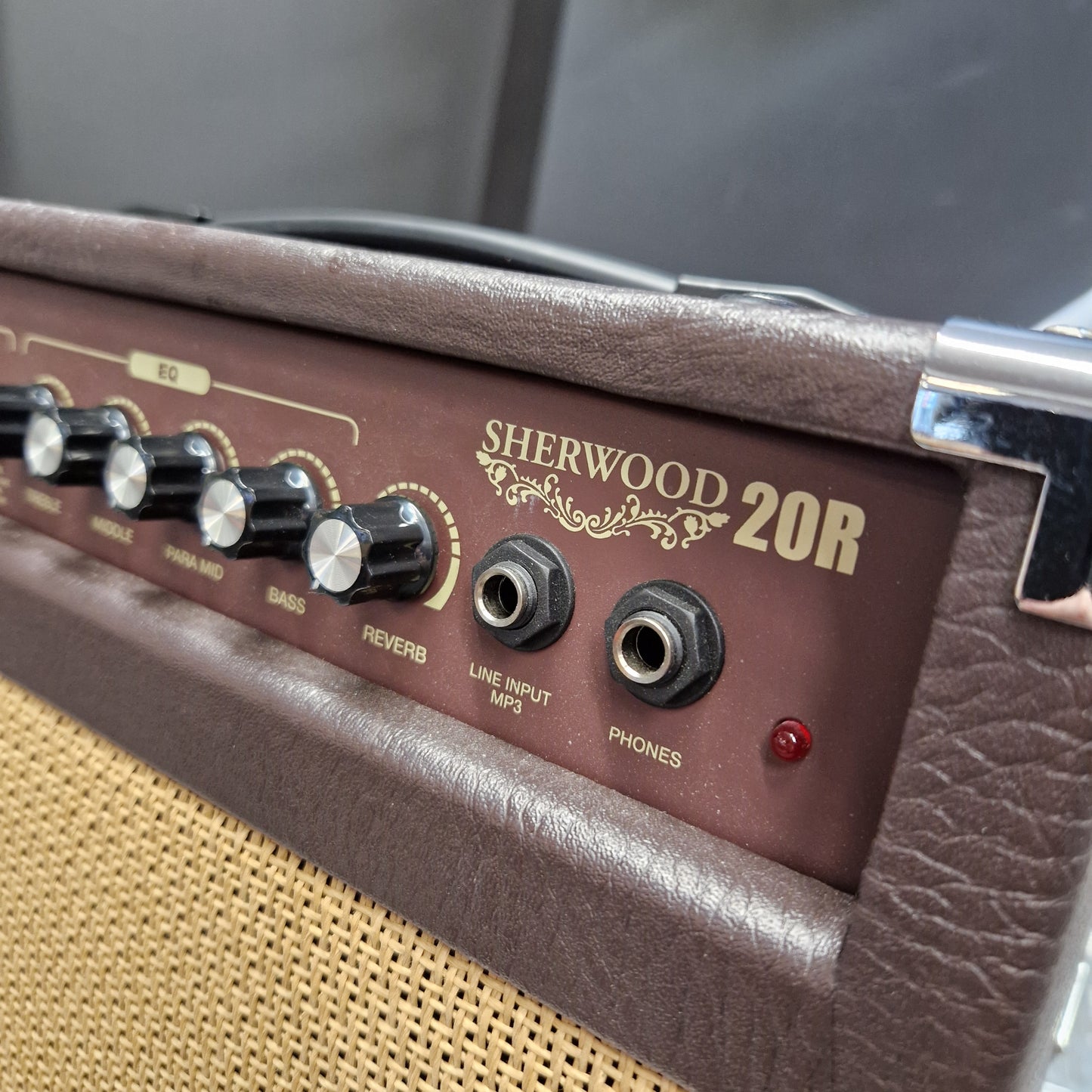 Pre-Owned Carlsbro Sherwood 20R Close-up of the control panel of a Sherwood 20W guitar amplifier, showing the brown textured cabinet, gold lettering, black knobs, and input jacks.