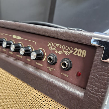 Pre-Owned Carlsbro Sherwood 20R Close-up of the control panel of a Sherwood 20W guitar amplifier, showing the brown textured cabinet, gold lettering, black knobs, and input jacks.
