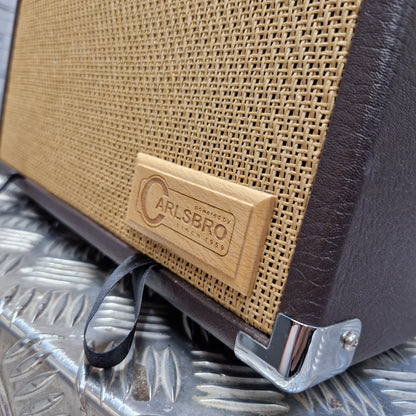 Pre-Owned Carlsbro Sherwood 20R Close-up of an Alesbro guitar amplifier showing the front grille, dark brown leather corners, and a silver metal corner brace.
