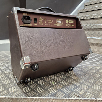 Pre-Owned Carlsbro Sherwood 20R A brown textured guitar amplifier head with a side panel showing controls and an input jack, photographed on a diamond plate metal surface.