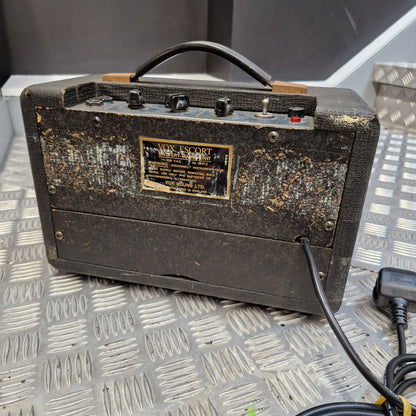 Pre-Owned Vox Escort A vintage Marshall amp head with a heavily worn, rusted black canvas cover, sitting on a diamond plate metal surface. The front features a gold-colored Marshall logo plate, black knobs, and a black carrying handle.