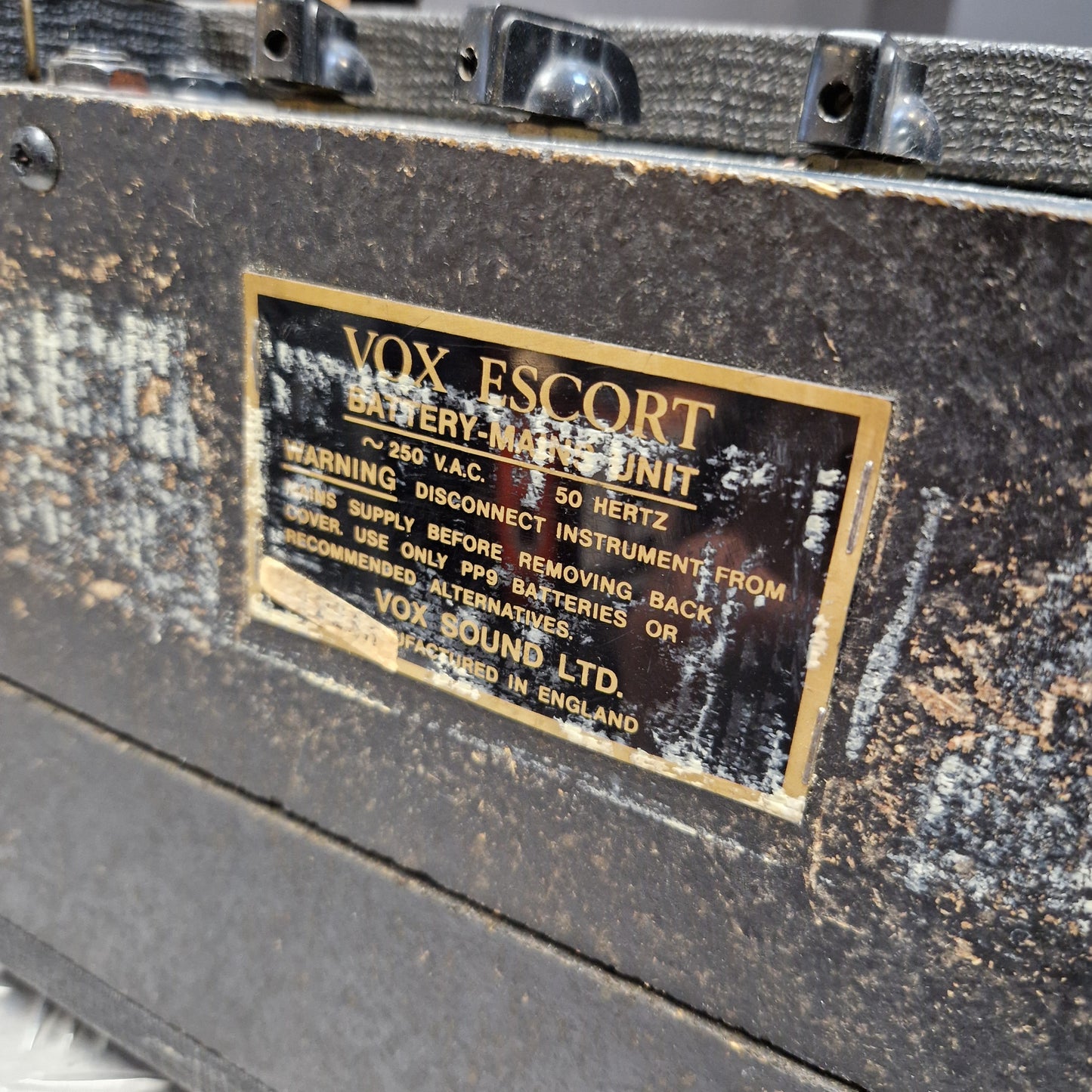 Pre-Owned Vox Escort Close-up of a vintage VOX Escort battery-machined unit showing a brass and black metal identification plate with gold lettering.