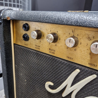 Pre-Owned Marshall JCM 800 Close-up of a vintage Marshall guitar amplifier showing the front grille, control knobs, and part of the white Marshall logo on a wooden panel.