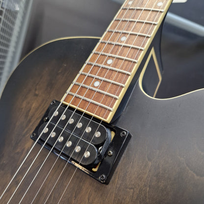 Pre-Owned Ibanez AF55-TKF Hollowbody Electric - Black Flat Close-up of an electric guitar body and neck, showing a dark brown to black sunburst finish, a black humbucker pickup with silver pole pieces, and a maple fretboard with white dot inlays.