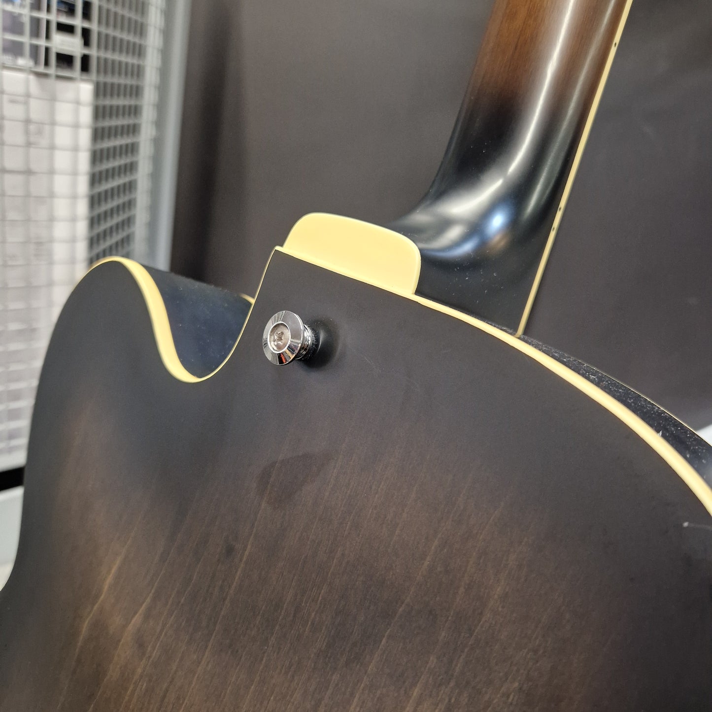 Pre-Owned Ibanez AF55-TKF Hollowbody Electric - Black Flat Close-up of the back of an electric guitar showing a dark brown wood finish, a cream binding edge, and a chrome tailpiece.