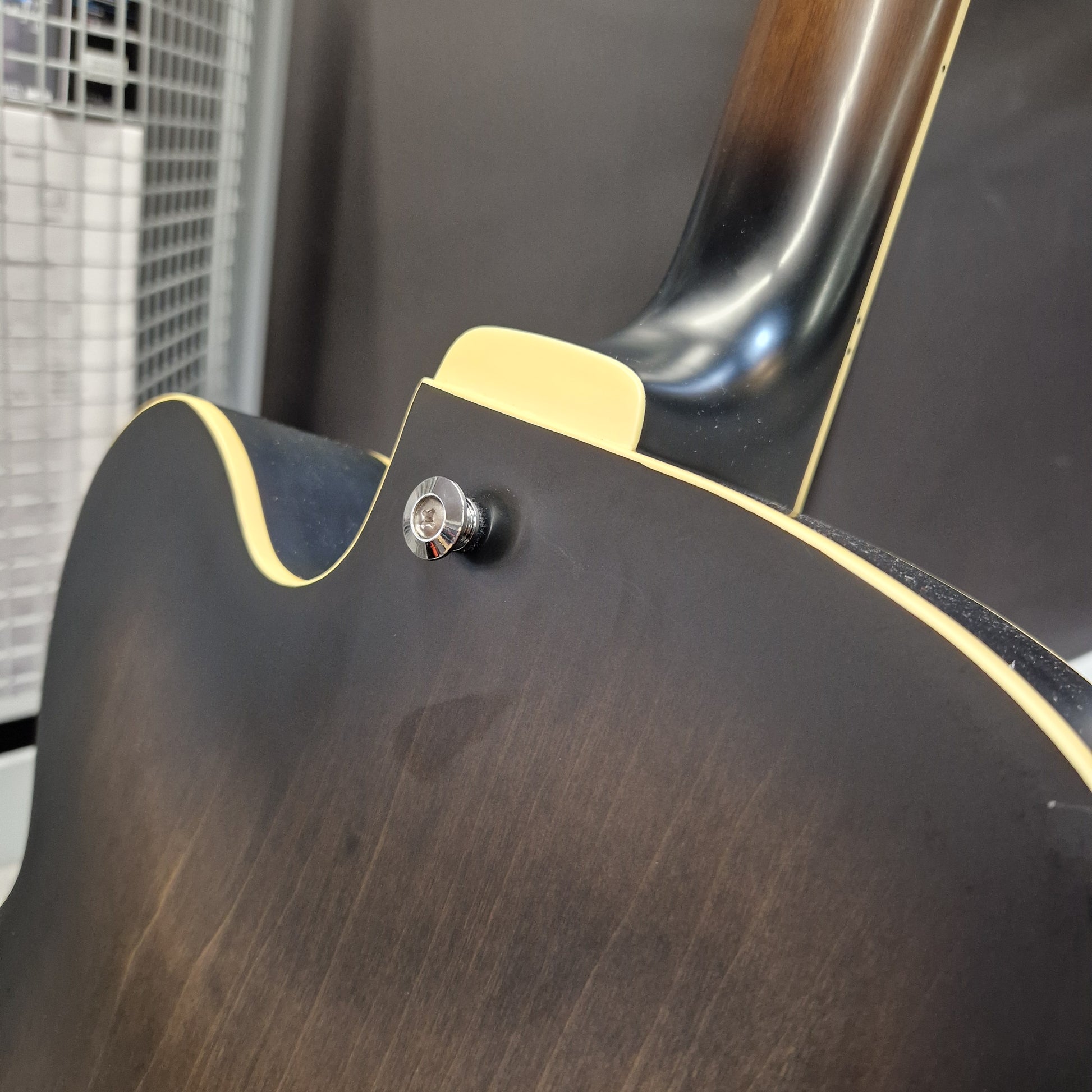 Pre-Owned Ibanez AF55-TKF Hollowbody Electric - Black Flat Close-up of the back of an electric guitar showing a dark brown wood finish, a cream binding edge, and a chrome tailpiece.