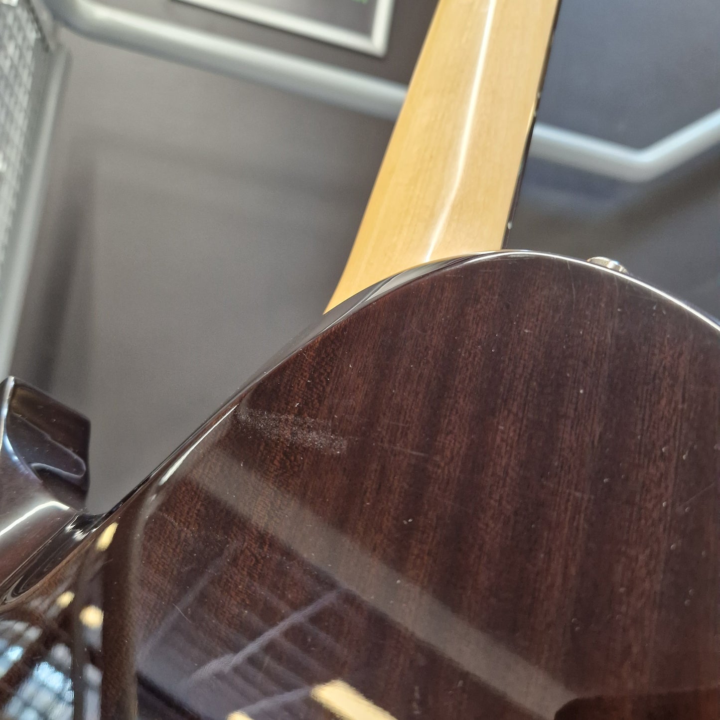 Pre-Owned Chapman ML-2 Electric - Grey Close-up detail of a dark brown wooden guitar body with a glossy finish and part of the light wood neck visible.