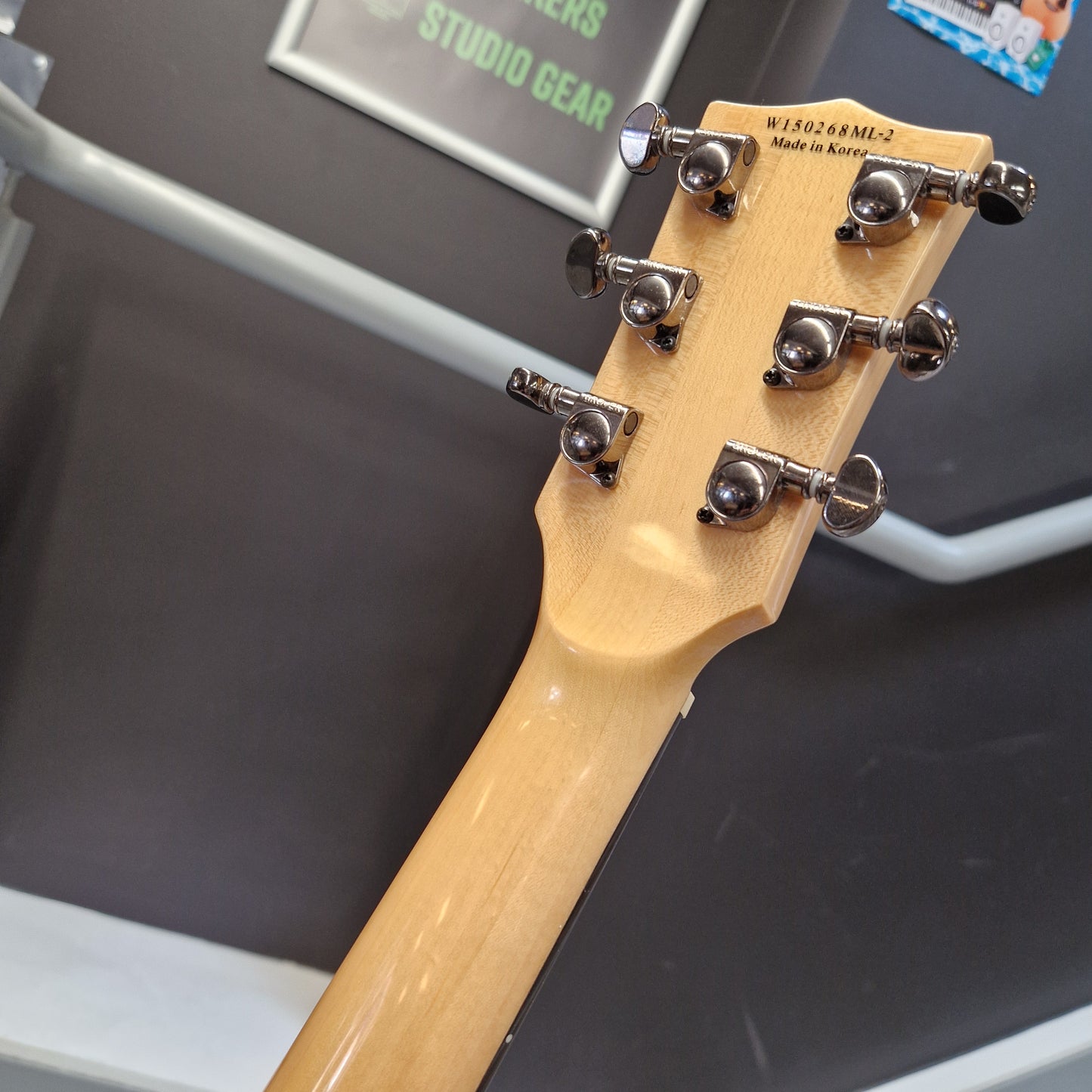 Pre-Owned Chapman ML-2 Electric - Grey Close-up of the headstock of a guitar, showing six silver tuning pegs and the brand name 'WYMO' printed on the light natural wood neck.