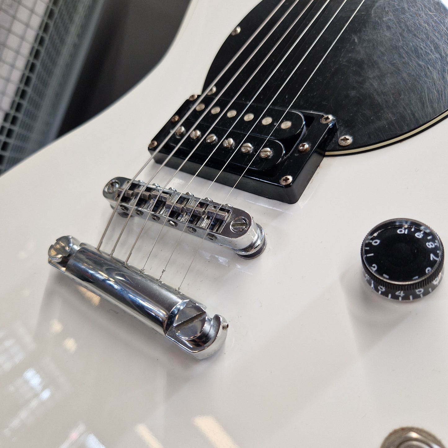 Pre-Owned Schecter Shaun Morgan Signature Electric - White Close-up of a white electric guitar body showing a black pickguard, chrome bridge and tailpiece, and a black control knob.