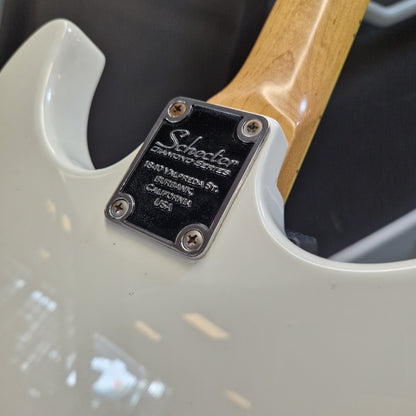 Pre-Owned Schecter Shaun Morgan Signature Electric - White Close-up of the back of an electric guitar body in off-white, showing a black Schoeler Chromatic Series plate with silver screws and a natural wood neck.