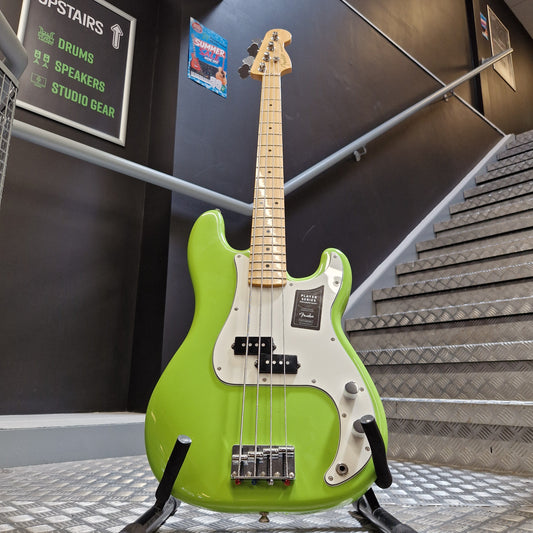 Pre-Owned Fender Player Precision Bass - Limited Edition Electron Green A bright lime green electric bass guitar with a maple neck and white pickguard, hanging on a stand in a store or studio setting.