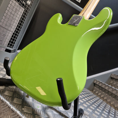 Pre-Owned Fender Player Precision Bass - Limited Edition Electron Green Close-up of the back body of a bright lime green electric guitar mounted on a black stand, with part of the light wood neck and a metal control plate visible.