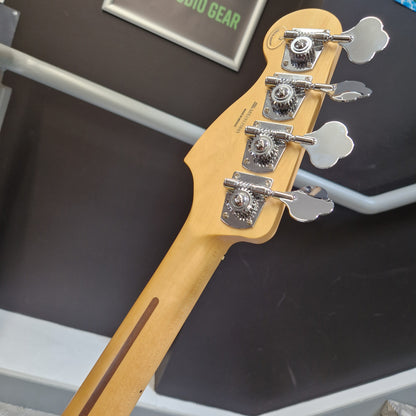 Pre-Owned Fender Player Precision Bass - Limited Edition Electron Green Close-up of the headstock and upper neck of a guitar, showing four silver tuning pegs and a light natural wood body against a dark display background.
