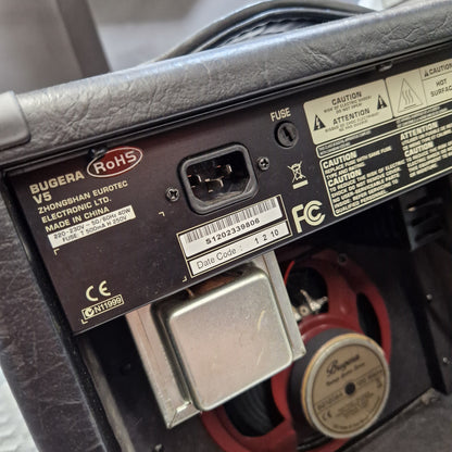 Pre-Owned Bugera Vintage 5 V5 Valve Guitar Combo Close-up of the rear power supply panel of a Bugaro V5 speaker, showing the power cord inlet, RoHS label, and internal components including a red speaker cone and metal heat sink.
