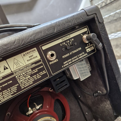 Pre-Owned Bugera Vintage 5 V5 Valve Guitar Combo Close-up of the rear panel of a black guitar amplifier or speaker cabinet, showing controls, labels, and a red speaker cone inside.
